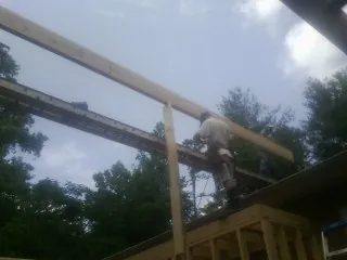 Carpenter setting a ridge beam over a new addition frame — Ice Dam Removal by Roofing Brothers in Indiahoma