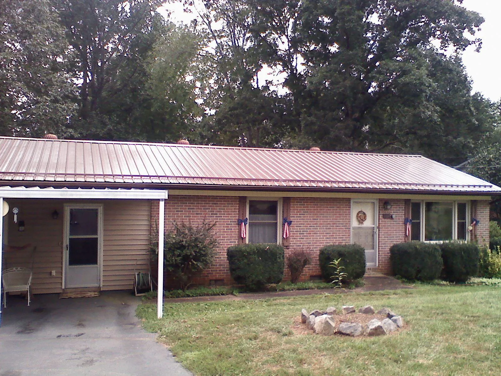 Bronze metal roof and carport on a brick ranch home — Roof Repair work by our crew in Indiahoma